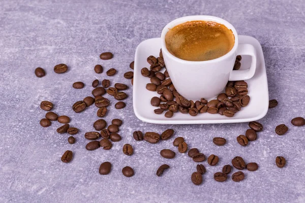 Café caliente en una taza, granos de café están dispersos cerca. Ver fro —  Fotos de Stock