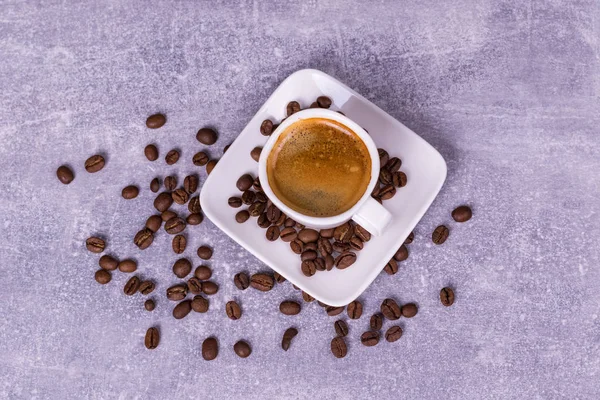 Café caliente en una taza, granos de café están dispersos cerca. Ver fro — Foto de Stock