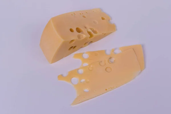 Un trozo de queso y rebanadas sobre un fondo blanco. Vista panorámica —  Fotos de Stock