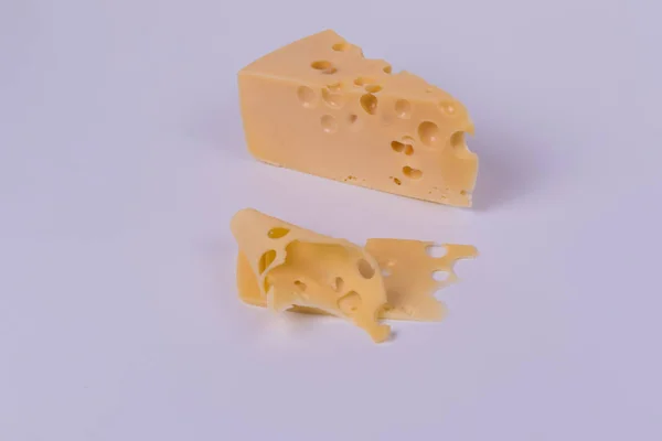Un trozo de queso y rebanadas sobre un fondo blanco. Vista panorámica —  Fotos de Stock