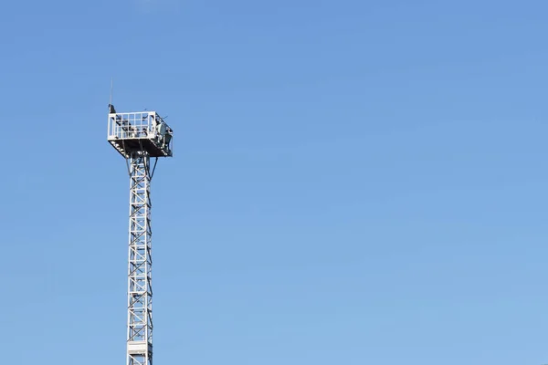 Torre con proyectores contra el cielo azul — Foto de Stock