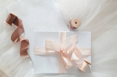 Süslü bir bantla bağlanmış beyaz hediye kutusu