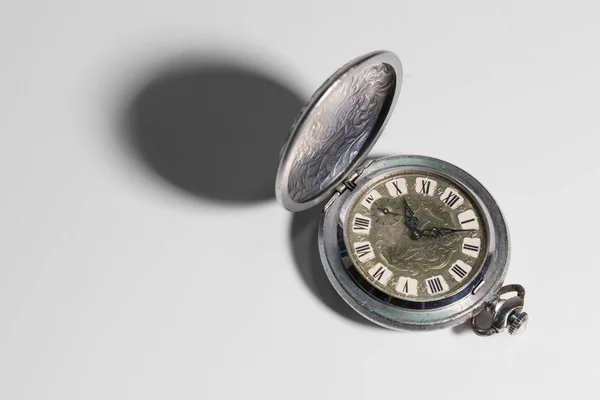 Old pocket metal watch on a white background.