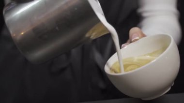 Cappuccino yapıyorum. Süt çizimi. Yukarıdan bak. Yakın plan.