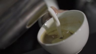 Cappuccino yapıyorum. Kahveye süt döker. Ağır çekim. Yukarıdan görüntüle