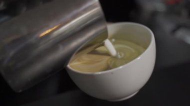 Cappuccino yapıyorum. Süt çizimi. Ağır çekim. Yukarıdan bak. Yakın plan.