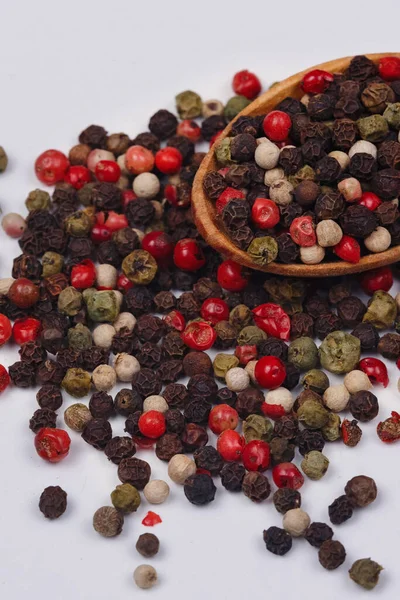 Een Mengsel Van Veelkleurige Peper Een Houten Lepel Een Witte — Stockfoto