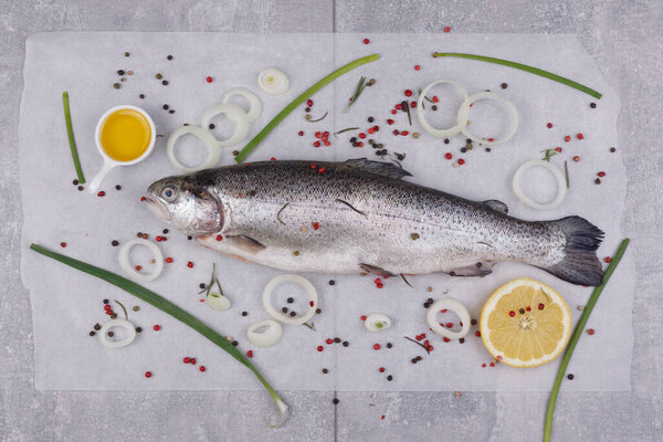 Trout, olive oil, lemon and onions. View from above.