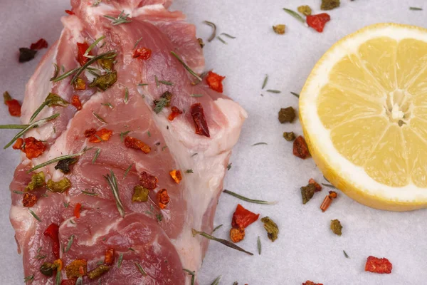 Spiced meat and lemon on paper. View from above. Close-up