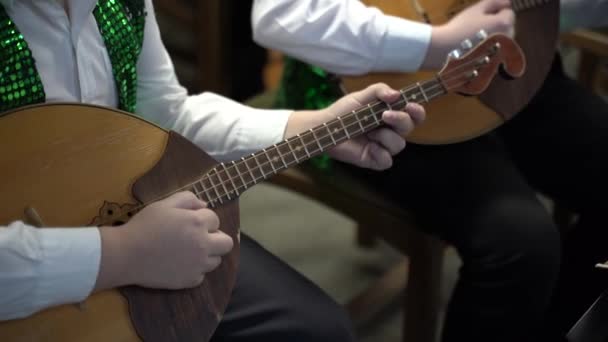 一个男孩在玩Domra 把双手和乐器合拢起来 — 图库视频影像