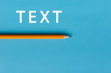 Yaratıcı düşünce (metin) için bir turuncu kalem ve alanın etkileşimli fotoğraf kompozisyonu eğitim, işletme veya yaratıcılık alanında sunum için kullanılır. Stüdyoda kalemle aydınlatma. Mavi arkaplan