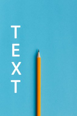 Yaratıcı düşünce (metin) için bir turuncu kalem ve alanın etkileşimli fotoğraf kompozisyonu eğitim, işletme veya yaratıcılık alanında sunum için kullanılır. Stüdyoda kalemle aydınlatma. Mavi arkaplan