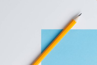 Yaratıcı düşünce (metin) için bir turuncu kalem ve alanın etkileşimli fotoğraf kompozisyonu eğitim, işletme veya yaratıcılık alanında sunum için kullanılır. Stüdyoda kalemle aydınlatma. Mavi ve beyaz arkaplan