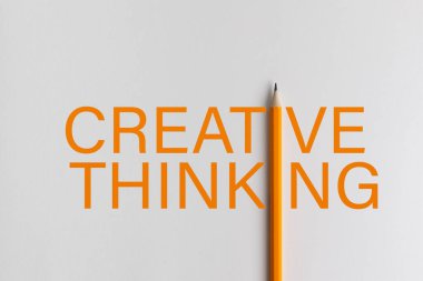 Turuncu kalem fotoğrafının etkileşimli bileşimi eğitim, iş dünyası veya yaratıcılık alanındaki sunumlarda kullanılan yaratıcı düşüncenin turuncu kelimelerinin yerini alır. Stüdyoda bir kalemi yakıyorum.