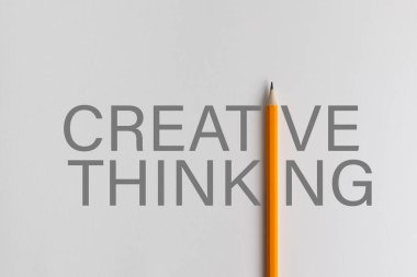 Sarı kalem fotoğraf kompozisyonu eğitim, iş dünyası veya yaratıcılık sunumu için kullanılan gri yaratıcı düşünce kelimelerinin yerini alıyor. Stüdyoda kalemle aydınlatma