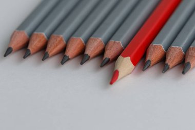 Beyaz bir arka planda kırmızı kalem ve gri kalemler. Lider konsepti, farklı, eşsiz