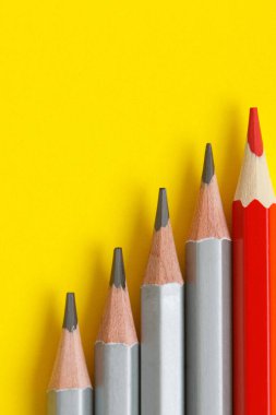 Sarı kağıtta kırmızı kalem ve gri kalemler. Lider kavramı, farklı, eşsiz. Metin