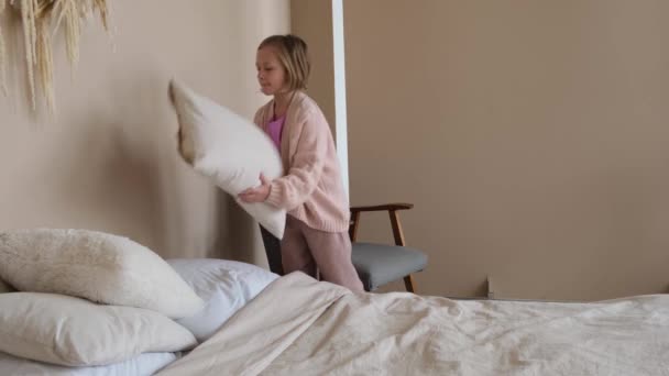 Девушка Заправляет Кровать Складывает Подушки Вид Сбоку — стоковое видео
