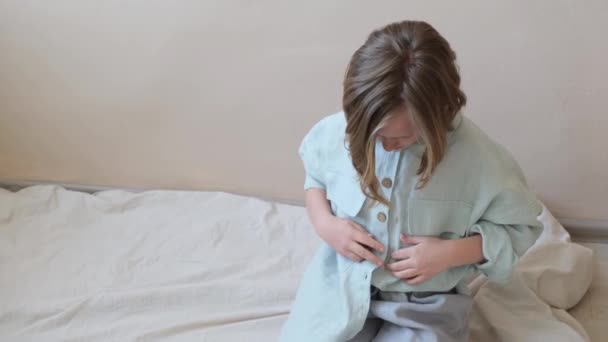 女の子は彼女のシャツをボタンで固定し 彼女の指からバリを削除します サイドビュー — ストック動画