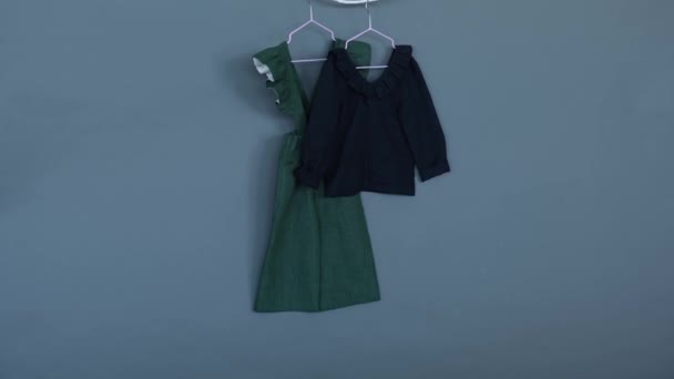 Dziecięce Ubrania Zielona Sukienka Czarna Bluzka Szarym Tle Izolacja — Wideo stockowe