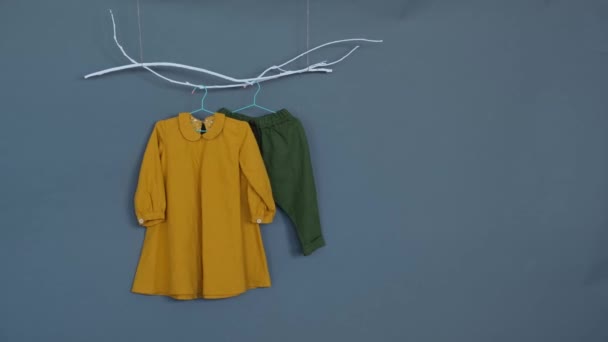 Des Vêtements Bébé Chemise Jaune Pantalon Vert Sur Fond Gris — Video