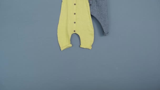Ρούχα Μωρού Γκρι Παντελόνι Και Κίτρινη Φόρμα Γκρι Φόντο — Αρχείο Βίντεο