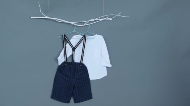 Ρούχα Μωρού Μπλε Σορτς Και Λευκό Πουκάμισο Γκρι Φόντο — Αρχείο Βίντεο