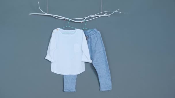 赤ちゃん服 グレーの背景に青いパンツと白いシャツ — ストック動画