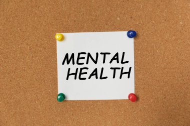Bir mantar panoya yapıştırılmış bir çıkartma üzerine yazılmış MENTAL Sağlık Metni