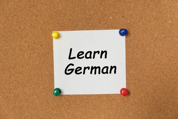 Text Learn German written on a sticker pinned on a cork board