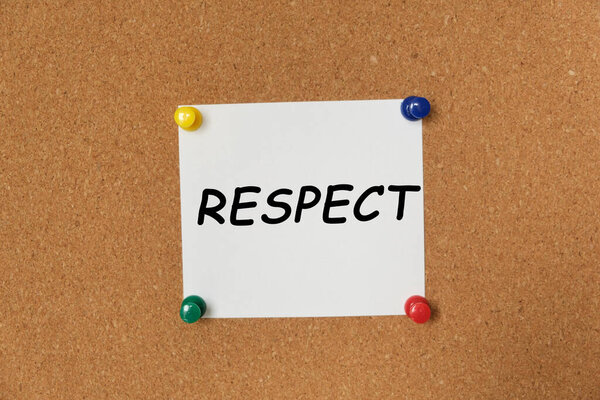 Text RESPECT written on a sticker pinned on a cork board