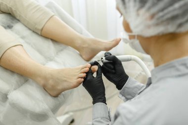 Operasyon sırasında usta donanım pedikürü. Çivi işleme ve öğütme. Yakın plan.