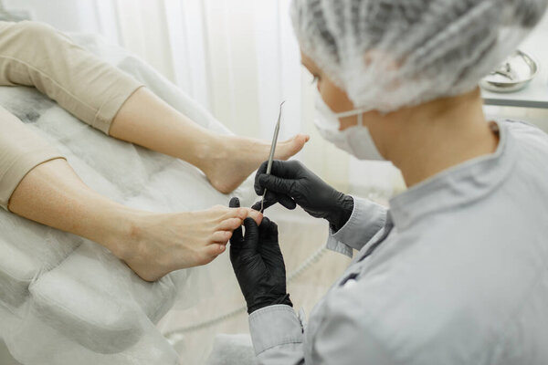 Master hardware pedicure during operation. Nail treatment. Close-up