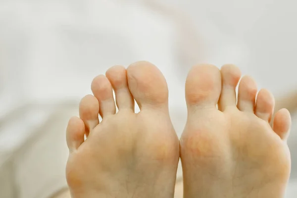 Two feet of a woman pressed against each other. Toes close-up, foot partially visible. Close-up