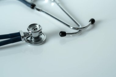 Beyaz yansıtıcı yüzeyde steteskop. Sağlık ve cerrahi konsept. Yakın plan..