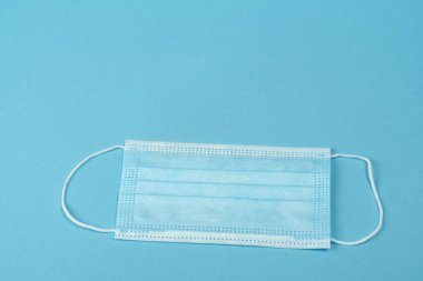 Plastik kulaklıklı cerrahi maske. Ağız ve burnu örtmek için tipik 3 katlı cerrahi maske. Bakterilerin prosedür maskesi. Koruma kavramı.