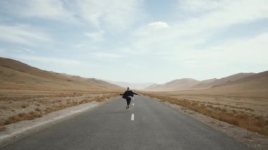 man beard mustache suit runs away road,raises hand up,rejoices around mountain