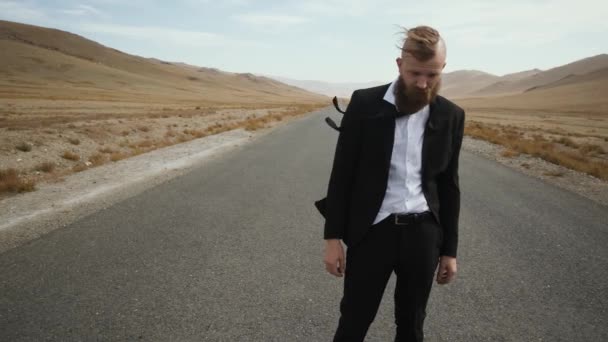 Man beard mustache suit.Office worker looking frame road among mountains alone — Stockvideo