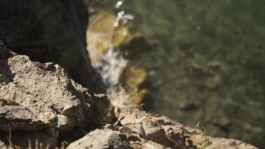 Uçurumun kenarından aşağıdaki suya bak, su kayalara çarpıyor.