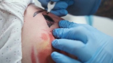 Dövme stüdyosu, adamın kolunda renk dövmesi var, kanaması var.