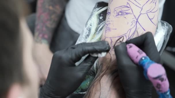 Studio tatuażu, facet robi sobie tatuaż na ramieniu, krwawi — Wideo stockowe