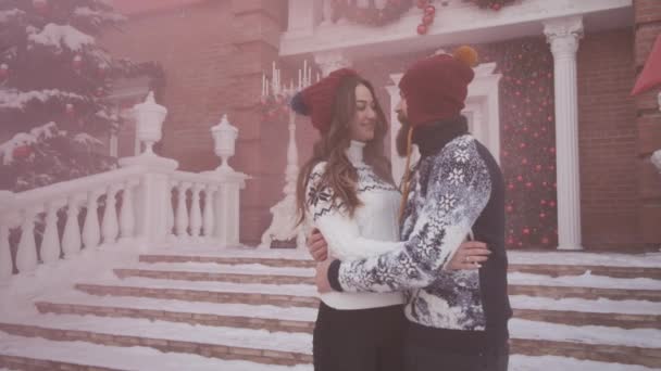 Jovem casal no Natal, ano novo jogar granada de fumaça rosa perto da casa decorada — Vídeo de Stock