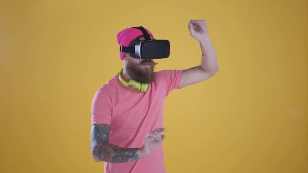 Hombre caucásico tocar algo usando gafas 3D vr modernas, fondo amarillo — Vídeos de Stock