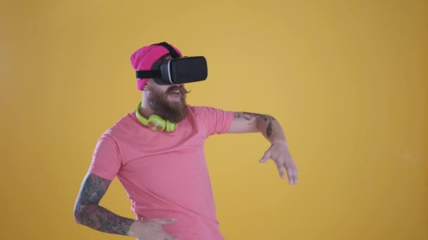 Hombre caucásico tocar algo usando gafas 3D vr modernas, fondo amarillo — Vídeos de Stock