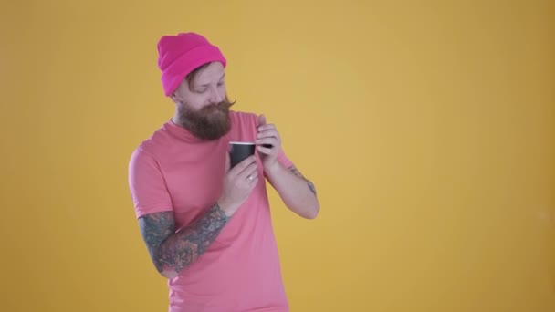 Caucasian man takes Cup of coffee sniffs smell and smiles,yellow background — Stock Video