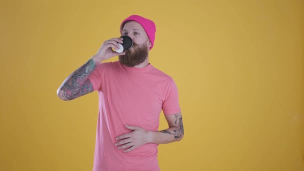 Kaukasiska manslin, hålla glas, dricka och njuta, gul bakgrund — Stockvideo