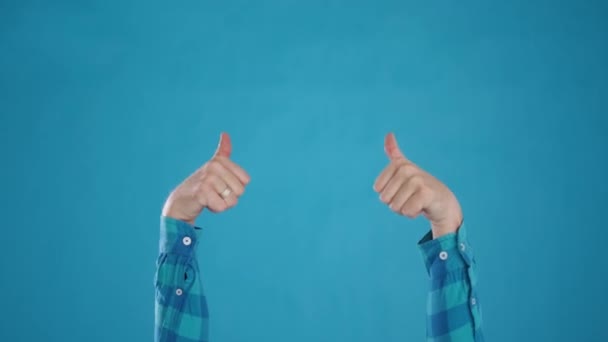 Kaukázusi kezek mutatják hűvös, hüvelykujj fel, OK, kék háttér közelkép — Stock videók
