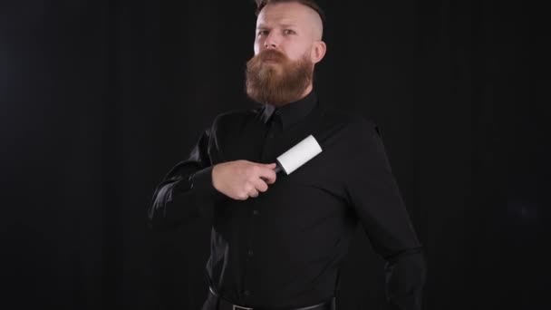 Mann reinigt Kleidung mit Walze von Staub und Partikeln schwarz — Stockvideo