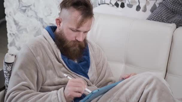 Man i housecoat ritning på surfplatta, arbetar hemma, designer i karantän — Stockvideo
