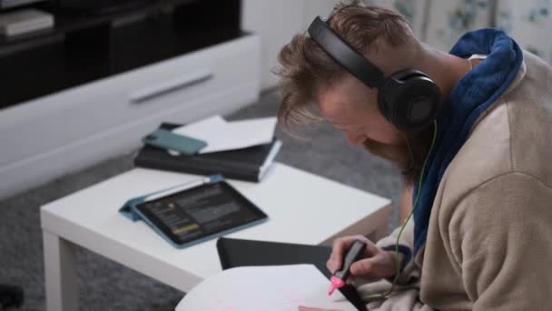 Hombre trabaja en casa en auriculares en cuarentena de la epidemia mundial de coronavirus — Vídeo de stock